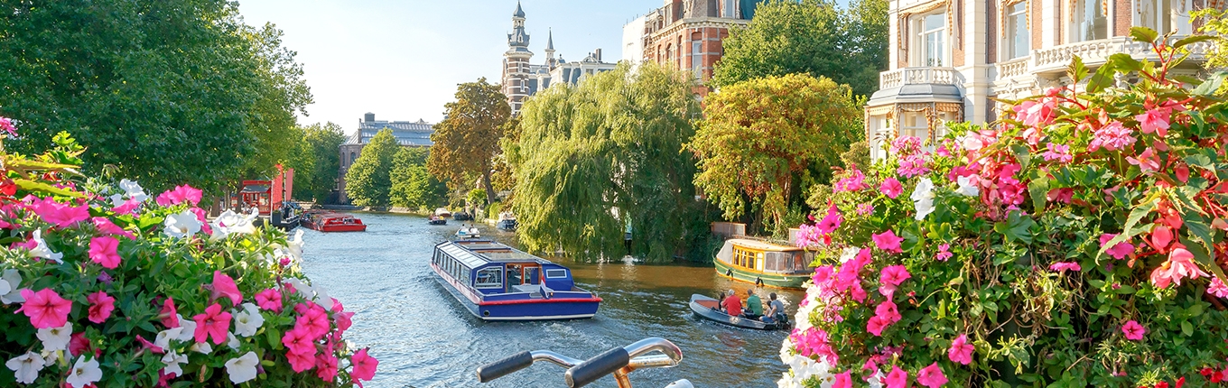 Amsterdam canals with boats view from a bridge with a bike