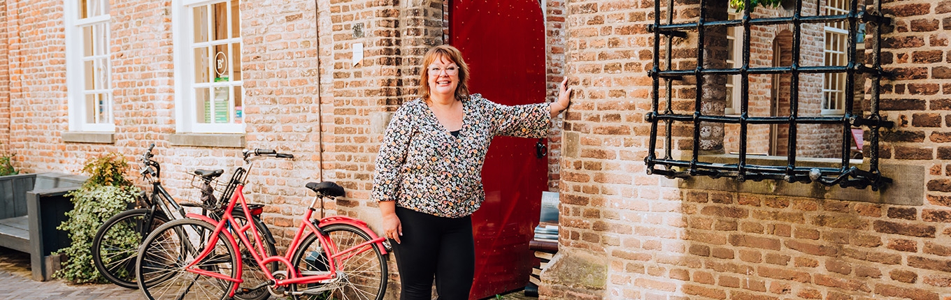 Judith Elders against building with red door