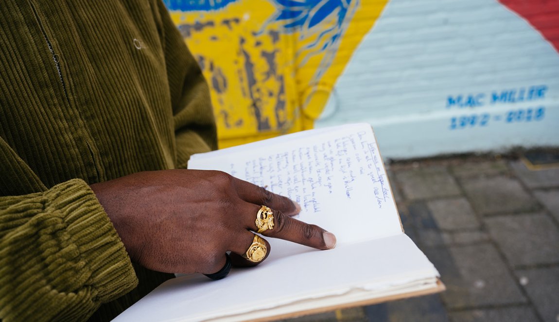 Portraitphoto Elten Kiene holding book in hands with large gold rings