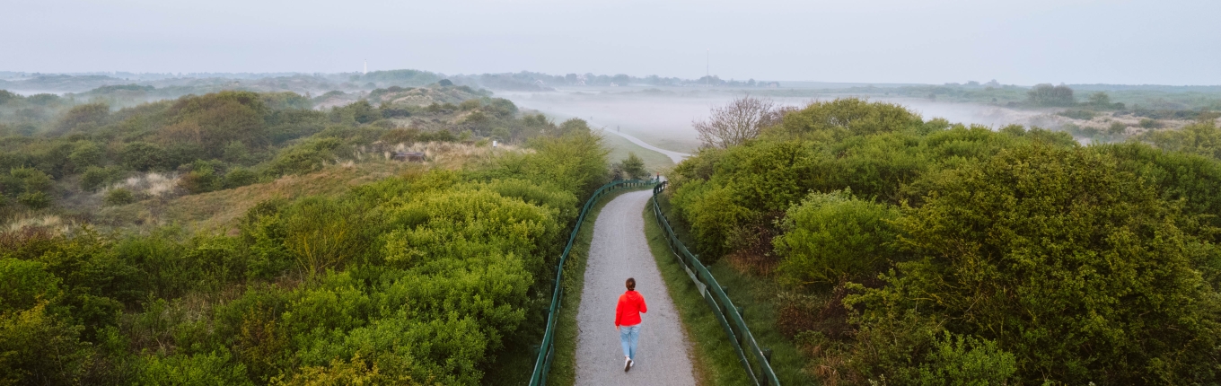 View of Schiermonnikoog with women in a red coat walking